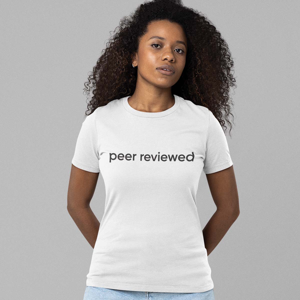 Woman wearing a white t-shirt with 'peer reviewed' black text standing against a gray background. Science t shirt, science tee, unisex science t shirt, short sleeve t shirt, short sleeve science t shirt